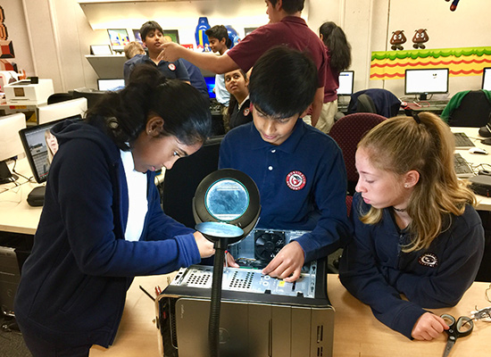 Students building a computer and learning about internal components.